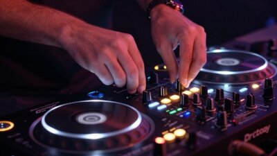 DJ mixando músicas em um equipamento profissional.